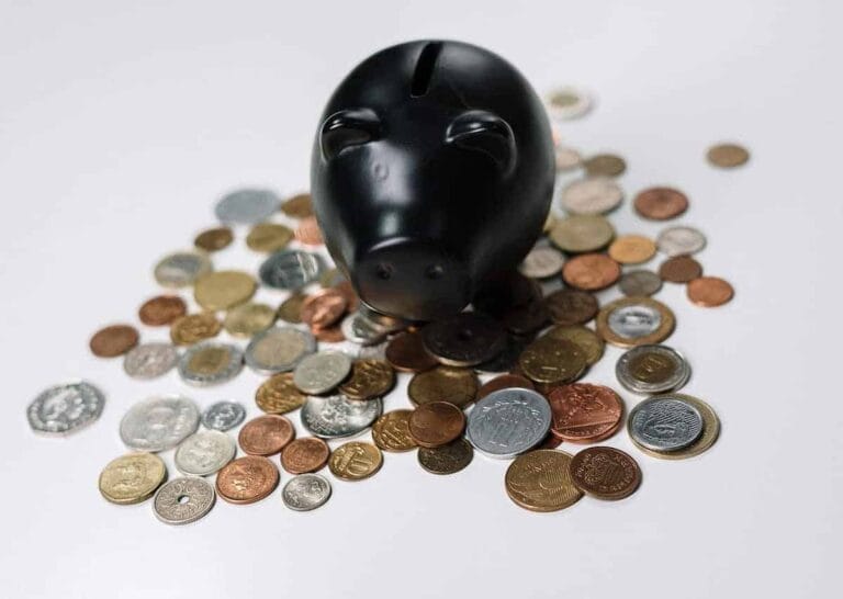 Piggy bank surrounded by assorted coins, symbolising savings and investment.