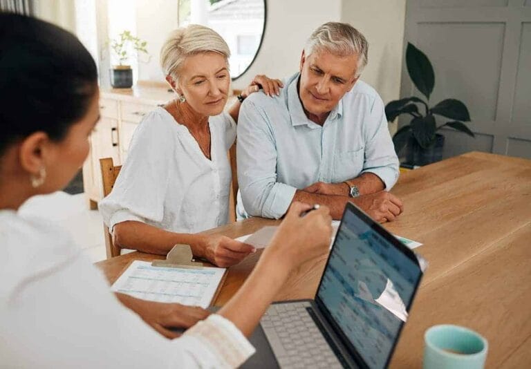 Financial planning consultation with mature couple at asset management firm.